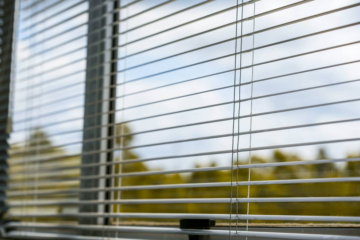what are smart curtains shown as motorized fabric panels on a modern patio window with remote control nearby