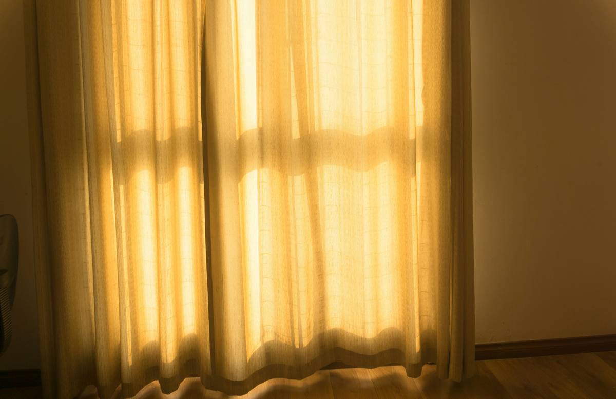 smart home smart curtains installed on a large patio window with sunlight filtering through